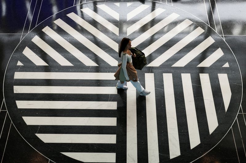 Fenomena Penumpang Pesawat Pakai Piama di Bandara AS A passenger makes her way through the terminal at Ronald Reagan Washington National Airport during the Thanksgiving holiday week, at Ronald Reagan Washington National Airport in Arlington, Virginia, U.S., November 25, 2025. REUTERS/Kevin Lamarque