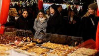 Orang-orang menunggu di depan kios makanan di Pasar Natal Notre-Dame Paris. REUTERS/Stephanie Lecocq