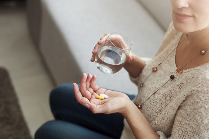 Ilustrasi wanita minum suplemen atau vitamin