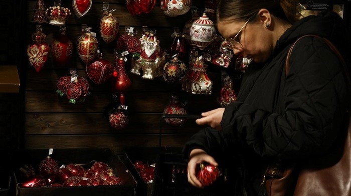 A worker heats glass before blowing a glass bauble at Silverado, a manufacturer of hand-blown Christmas ornaments, in Jozefow, outside Warsaw, Poland, December 2, 2025. REUTERS/Kacper Pempel