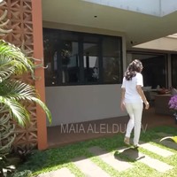 Rumah Maia tampak asri dengan beragam pohon dan bunga-bunga yang indah. Dalam foto terlihat bunda Corla yang melihat-lihat ke bagian belakang rumah Maia. Foto: YouTube/MAIA ALELDUL TV