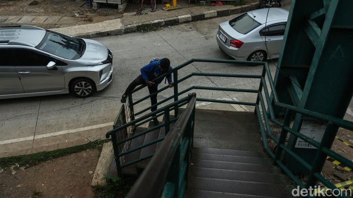 Warga menyeberang jalan Ahmad Yani, Bekasi, Selasa (9/12/2025). Jembatan Penyeberangan Orang (JPO) di jalan Ahmad Yani, Bekasi viral tanpa pengaman. Besi-besi yang harusnya jadi pengaman hilang.