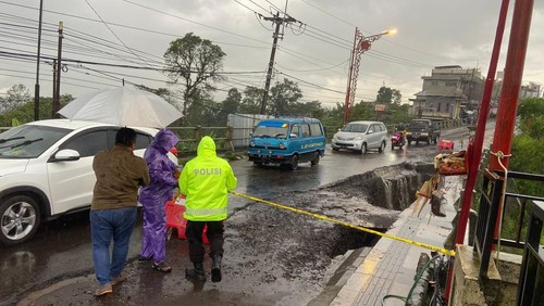 Polisi memasang water barrier dan police line di Jalan Raya Penelokan-Kintamani, jebol, Selasa (9/12/2025). (Dok. Polsek Kintamani)