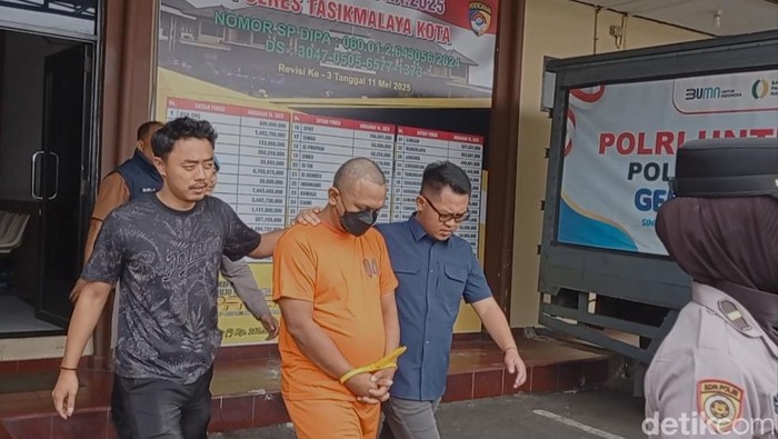 Polisi saat menggelandang pelaku pemalsuan tepung terigu di Tasikmalaya.