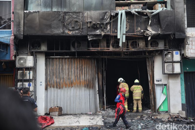 Petugas pemadam kebakaran mengeluarkan asap saat melakukan pencarian korban kebakaran di perkantoran Terra Drone di jalan Letjen Soeprapto, Cempaka Baru, Kemayoran, Jakarta Pusat, Selasa (9/12/2025) pukul 17.15 WIB.