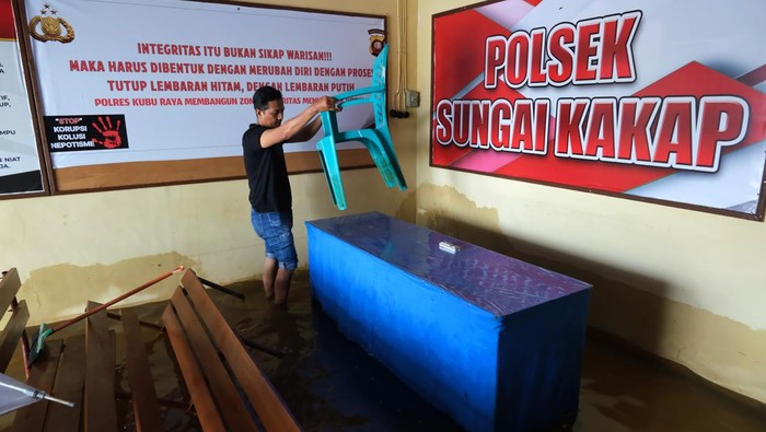Sejumlah polisi melaksanakan apel pagi di tengah banjir rob di halaman Polsek Sungai Kakap, Kabupaten Kubu Raya, Kalimantan Barat, Selasa (9/12/2025). Banjir rob yang melanda daerah itu sejak Senin (8/12) merendam kantor Polsek Sungai Kakap namun pelayanan kepada masyarakat tetap berlangsung, sementara para tahanan telah dipindahkan ke Polres Kubu Raya. ANTARA FOTO/Jessica Wuysang
