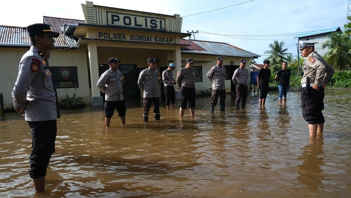 Sejumlah polisi melaksanakan apel pagi di tengah banjir rob di halaman Polsek Sungai Kakap, Kabupaten Kubu Raya, Kalimantan Barat, Selasa (9/12/2025). Banjir rob yang melanda daerah itu sejak Senin (8/12) merendam kantor Polsek Sungai Kakap namun pelayanan kepada masyarakat tetap berlangsung, sementara para tahanan telah dipindahkan ke Polres Kubu Raya. ANTARA FOTO/Jessica Wuysang