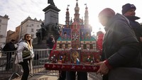 Peserta membawa diorama Szopka buatan tangan melalui alun-alun Krakow saat parade tahunan digelar, menandai dimulainya kompetisi tradisional yang telah berlangsung 83 tahun. Foto: REUTERS/Kuba Stezycki