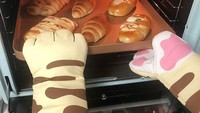 Hadapi panas dapur dengan gaya yang Purr-fect dan perlindungan optimal. Sarung tangan oven cakar kucing ini tidak hanya lucu, tetapi juga menawarkan ketahanan panas yang sangat baik, mampu menahan panas tinggi seperti saat memegang wajan. Mengeluarkan masakan dari oven kini menjadi momen yang penuh kegemasan. Dok. Bored Panda