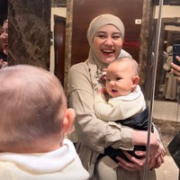 Aaliyah pun ikut menjaga dan sesekali menggendong putra kecilnya itu. Tampil dengan busana syari warna nude, Aaliyahh terlihat cantik dengan pulasan makeup minimalis. Foto: Instagram/@thariqhalilintar