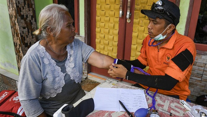 Petugas kesehatan dari Basarnas gabungan memeriksa kesehatan warga korban bencana tanah longsor dan banjir bandang di Kelurahan Sipange, Kecamatan Tukka,Tapanuli Tengah, Sumatera Utara, Selasa (9/12/2025). Metode jemput bola digunakan untuk menjangkau warga yang kesulitan mendapat layanan karena rusaknya fasilitas kesehatan dan akses jalan akibat tanah longsor dan banjir bandang. ANTARA FOTO/Muhammad Adimaja/foc.