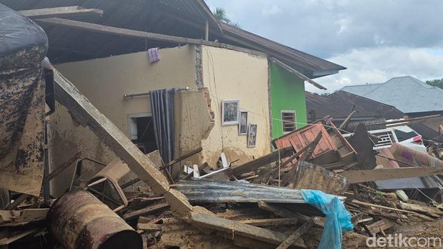 Bagian ruang tamu rumah Kenael Yoris (29) tersapu galodo meninggalkan potret pernikahan di dinding yang terekspos keluar. Bagian ruang tamu rumah Kenael Yoris (29) tersapu galodo meninggalkan potret pernikahan di dinding yang terekspos keluar, Senin (8/12/2025).