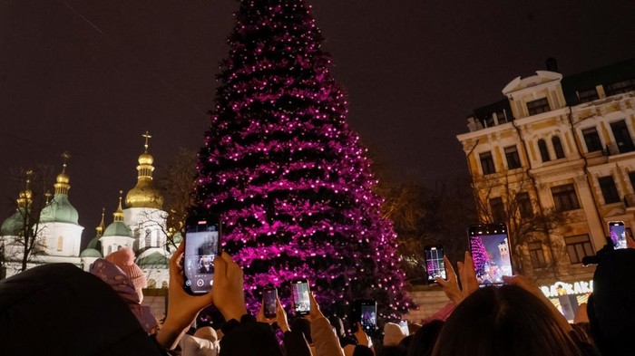 People take pictures as they gather around Ukraine's main Christmas tree after its lights were switched on, amid Russia's attack on Ukraine, in front of St. Sophia's Cathedral in Kyiv, Ukraine December 5, 2025. REUTERS/Gleb Garanich
