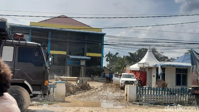 Kantor PLN Kuala Simpang masih dipenuhi lumpur. Proses pembersih terlihat dilokasi. (Foto: Nizar Aldi/detikSumut).