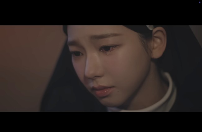 “Pretty crier,” tulis para penggemar di media sosial, terpana dengan kecantikan Karina aespa bahkan ketika menangis. Penampilannya sebagai biarawati kian bermakna karena ia diketahui beragama Katolik dan memiliki nama baptis Katarina. Foto: dok. YouTube @DolphinersOfficial