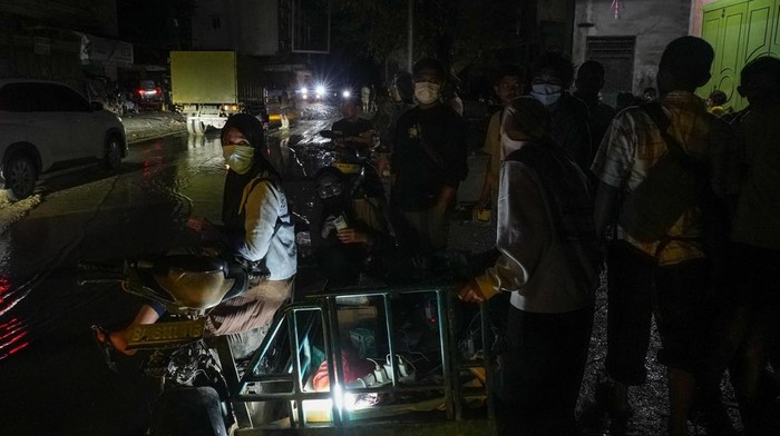 Sejumlah warga berdiri di salah satu sudut pusat kota Kuala Simpang yang gelap akibat jaringan listrik belum pulih di Kabupaten Aceh Tamiang, Aceh, Selasa (9/12/2025). Menteri ESDM Bahlil Lahadalia meminta maaf kepada masyarakat Aceh karena belum seluruhnya akses listrik pulih hingga dua pekan pascabencana banjir bandang. ANTARA FOTO/Erlangga Bregas Prakoso