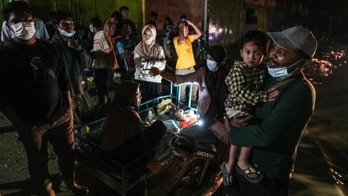 Sejumlah warga berdiri di salah satu sudut pusat kota Kuala Simpang yang gelap akibat jaringan listrik belum pulih di Kabupaten Aceh Tamiang, Aceh, Selasa (9/12/2025). Menteri ESDM Bahlil Lahadalia meminta maaf kepada masyarakat Aceh karena belum seluruhnya akses listrik pulih hingga dua pekan pascabencana banjir bandang. ANTARA FOTO/Erlangga Bregas Prakoso