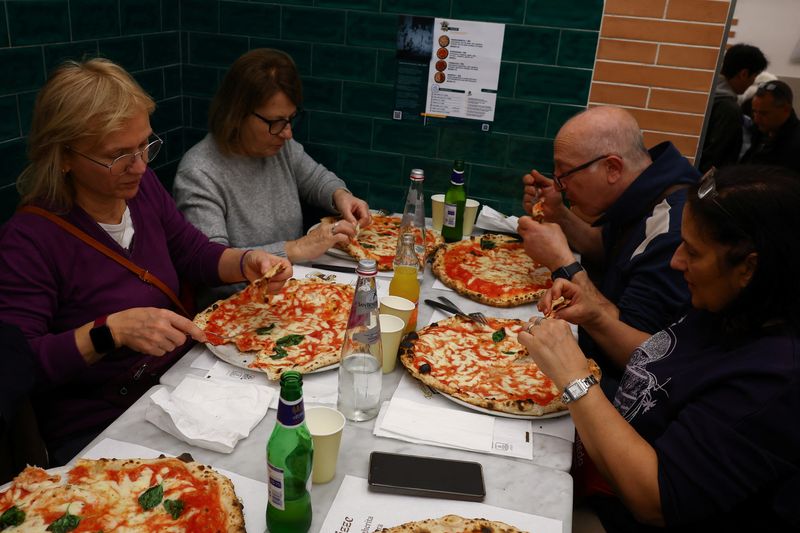 Pasta hingga Pizza, Italia Bidik Status Warisan Dunia dari UNESCO People eat pizzas at L'antica Pizzeria da Michele as Italian cuisine awaits a crucial UNESCO decision that could recognise it as an Intangible Cultural Heritage of Humanity in Naples, Italy, December 5, 2025. REUTERS/Ciro De Luca