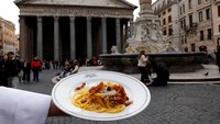 Seorang pelayan menunjukkan sepiring pasta Carbonara tradisional di depan Pantheon. Daftar Warisan Budaya Takbenda UNESCO sudah mencakup hidangan haute cuisine yang disiapkan untuk hari Minggu atau acara perayaan di Prancis. Meksiko juga telah diakui atas hidangan perayaan yang terkait dengan ritual keagamaan minoritas etnis. Foto: REUTERS/Remo Casilli