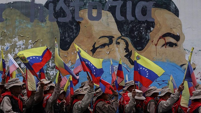 CARACAS, VENEZUELA - DECEMBER 10: Members of the Bolivarian militia wave Venezuelan flags during a commemoration march for the 166th Anniversary of the Battle of Santa Inés on December 10, 2025 in Caracas, Venezuela. Fought on December 10, 1859, the Battle of Santa Inés was a turning point in the Venezuelan Federal War between the Federalist forces and the conservative government forces. (Photo by Jesus Vargas/Getty Images)