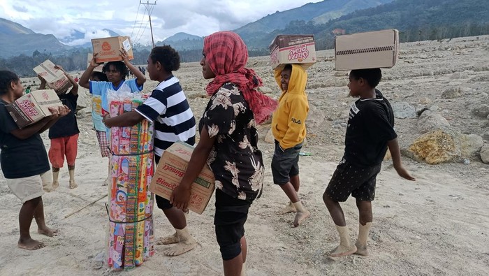 Warga Kampung Pobiatma korban banjir dan longsor membawa bantuan dari pemerintah di Distrik Asotipo, Kabupaten Jayawijaya, Papua Pegunungan, Rabu (10/12/2025). Banjir dan tanah longsor melanda Kampung Pobiatma pada Minggu (7/12) malam yang dipicu curah hujan tinggi di wilayah tersebut hingga menyebabkan akses Jalan Trans Wamena–Kurima sementara tidak dapat dilalui karena tertutup material lumpur, tanah, dan bebatuan. ANTARA FOTO/Yudhi Efendi