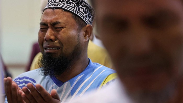 Afridoni, a local man, cries while attending funeral prayers for unidentified victims of the recent flash floods and landslides at the Great mosque of Syekh Ahmad Khatib Al-Minangkabawi in Padang, West Sumatra province, Indonesia, December 10, 2025. REUTERS/Willy Kurniawan TPX IMAGES OF THE DAY