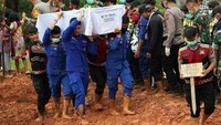 Petugas polisi membawa peti mati seorang Korban tak dikenal dari banjir bandang dan tanah longsor untuk dimakamkan. Jumlah korban tewas akibat banjir dan tanah longsor yang disebabkan oleh siklon mencapai 967 jiwa hingga Rabu (10/12), dengan 262 orang masih hilang, menurut data resmi. REUTERS/Willy Kurniawan