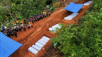 Pemandangan dari drone menunjukkan pemakaman massal korban tak dikenal dari banjir bandang dan tanah longsor. Sekitar 5.000 orang juga terluka akibat bencana tersebut. Foto: REUTERS/Willy Kurniawan