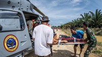 Personel KRI dr Soeharso-990 bersama warga membantu mengangkat korban menuju helikopter yang sudah siaga. Proses penyelamatan berlangsung hati-hati karena kondisi medan sulit. ANTARA FOTO/Bayu Pratama S