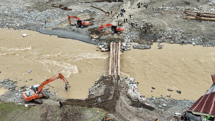 Warga melintasi jembatan darurat penghubung Kabupaten Aceh Tengah dan Kabupaten Nagan Raya di Desa Blang Beurandeh, Kecamatan Beutong Ateuh Banggalang, Nagan Raya, Aceh, Kamis (11/12/2025). Pembangunan jembatan darurat tersebut untuk memulihkan dan memperlancar arus lalu lintas yang sempat terputus pascabencana hidrometeorologi pada Rabu (26/11) lalu. ANTARA FOTO/Syifa Yulinnas/rwa.