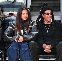 Ia melengkapi look-nya dengan wedge sneakers bertali, tas silver  dari Diesel, dan perhiasan berupa tumpukan kalung serta anting emas.  Foto: Getty Images/Allen Berezovsky