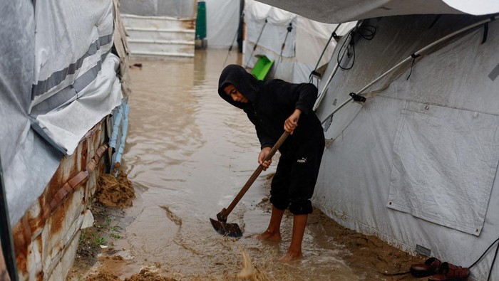 Displaced Palestinians in a tent camp on a rainy day in Nuseirat, central Gaza Strip, December 11, 2025. REUTERS/Mahmoud Issa