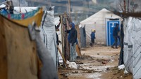 Deretan tenda yang basah tertiup angin dingin, sementara warga berusaha menjaga barang dan dapur mereka tetap kering. Medis di Gaza melaporkan seorang bayi berusia 8 bulan tewas akibat paparan dingin setelah tenda keluarganya terendam air. REUTERS/Mahmoud Issa
