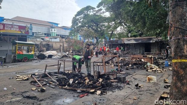 Lokasi kericuhan usai pengeroyokan di kawasan Kalibata, Jaksel digaris polisi. Petugas PPSU membersihkan puing-puing di tempat kejadian perkara (TKP). (Taufiq S/detikcom)