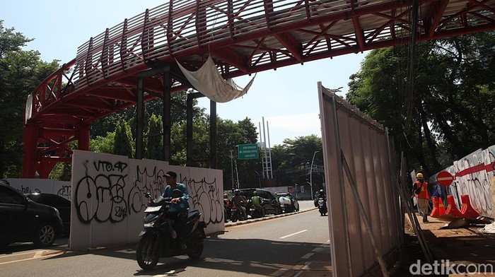 Para pekerja melakukan pembangunan jembatan penghubung (skybridge) pada proyek ruang terbuka hijau Taman Bendera Pusaka, Kramat Pela, Kebayoran Baru, Jakarta Selatan, Jumat (12/12/2025). Jembatan tersebut menghubungkan Taman Ayodya dan Taman Langsat. Bersama Taman Leuser, ketiganya akan disatukan menjadi Taman Bendera Pusaka.