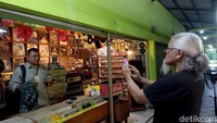 Pengunjung sedang meminta foto dengan latar belakang barang-barang antik di Pasar Nostalgia.