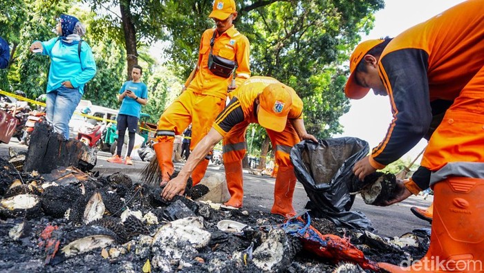 Petugas kebersihan dikerahkan untuk membersihkan sisa puing kebakaran di kawasan Kalibata, Jaksel, setelah kericuhan yang terjadi semalam, Jumat (12/12/2025).