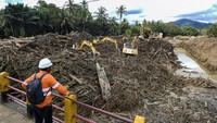 Petugas menggunakan alat berat membersihkan gelondongan kayu yang menutupi aliran sungai Aek Garoga pascabencana banjir bandang dan tanah longsor di Kabupaten Tapanuli Tengah, Sumatera Utara.Foto: ANTARA FOTO/Muhammad Adimaja