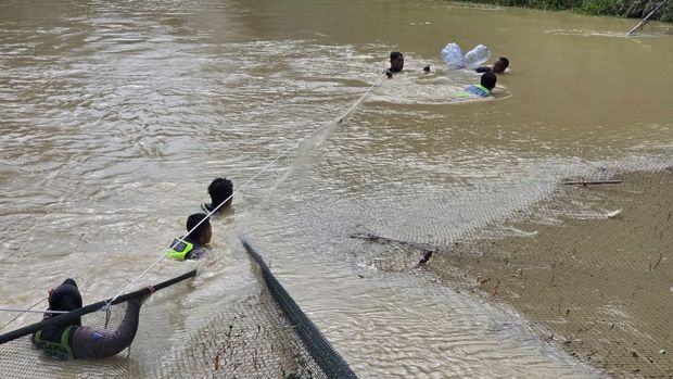 Polwan Polres Blora, Brigpol Titis Widya, saat menyusuri Sungai Embung Jetis untuk mencari tiga santriwati tenggelam yang masih belum ditemukan.