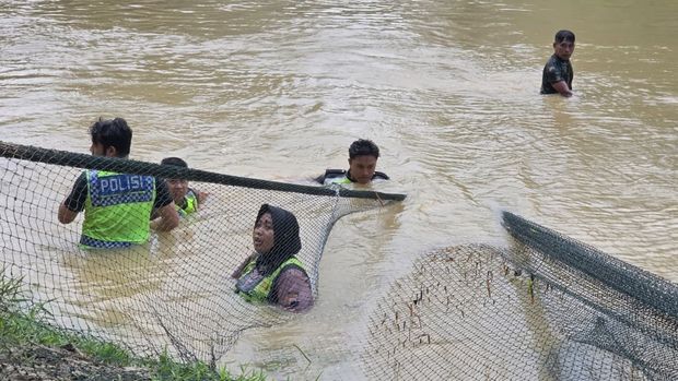 Polwan Polres Blora, Brigpol Titis Widya, saat menyusuri Sungai Embung Jetis untuk mencari tiga santriwati tenggelam yang masih belum ditemukan.