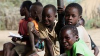 Anak-anak Turkana duduk di luar pusat kesehatan Naoros di Kabupaten Turkana, saat sistem skrining yang dulu menjangkau 75% wilayah kini turun ke bawah 15% akibat berkurangnya pendanaan dan berhentinya program outreach. REUTERS/Monicah Mwangi