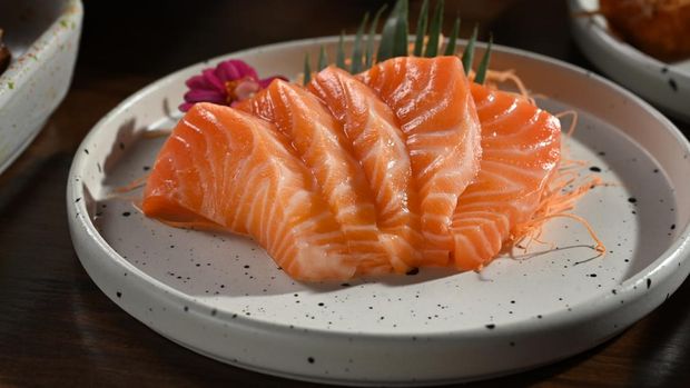 A plate of salmon sashimi on wooden table. Japanese food style concept.