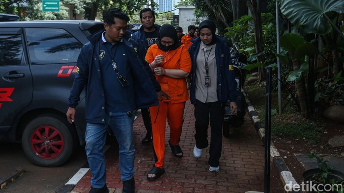 Tersangka Bos WO Ayu Puspita tertunduk lesu saat digiring polisi di Polda Metro Jaya, Jakarta, Sabtu (13/12/2025).