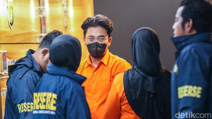 Tersangka Bos WO Ayu Puspita tertunduk lesu saat digiring polisi di Polda Metro Jaya, Jakarta, Sabtu (13/12/2025).