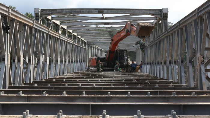 Prajurit TNI Kodam Iskandar Muda bersama petugas Kementerian Pekerjaan Umum menyelesaikan pembangunan jembatan bailey untuk memperbaiki sementara jembatan Juli yang rusak akibat bencana banjir bandang di Bireuen, Aceh, Sabtu (13/12/2025). Pembangunan jembatan bailey di jalan lintas tengah Aceh yang menghubungkan Kabupaten Bireuen dengan Kabupaten Bener Meriah dan beberapa kabupaten lain di dataran tinggi Gayo telah mencapai 87 persen dan ditargetkan dapat dilintasi pada 15 Desember 2025. ANTARA FOTO/Irwansyah Putra/tom.