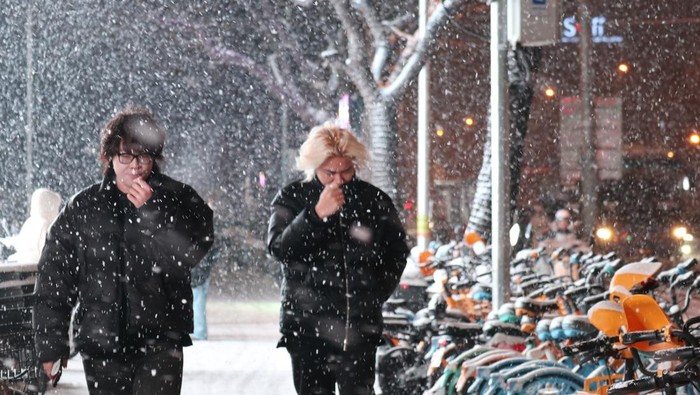 Warga melintasi kompleks Forbidden City di Beijing saat turun salju perdana pada Jumat (12/12/2025). Biro Meteorologi Beijing mengumumkan hujan salju besar pertama pada musim dingin turun dengan ketebalan 4-8 milimeter dengan suhu di ibu kota akan turun tajam yaitu minus 3 derajat Celsius pada Jumat (12/12) dan anjlok hingga minus 10 derajat Celsius pada Sabtu (13/12) malam. ANTARA FOTO/Desca Lidya Natalia/foc.