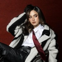 Ia mengenakan mantel berbahan tebal bernuansa hitam-putih. Mantel tersebut memiliki cutting oversized, memberi kesan bold, modern, sekaligus high fashion. Foto: Instagram/@syifahadju