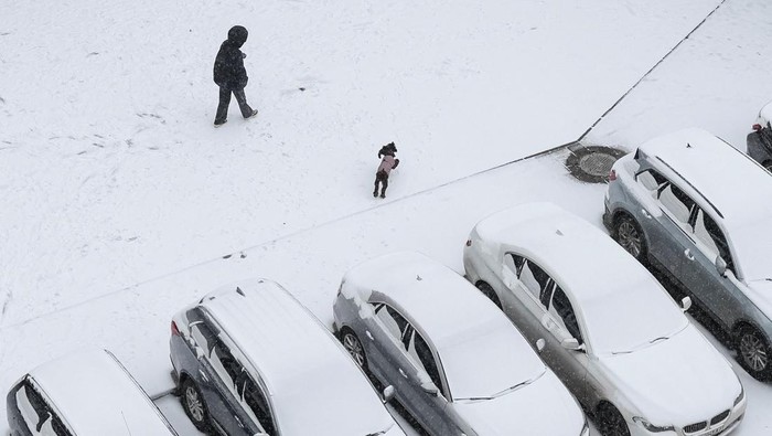 Salju pertama musim dingin turun di Kyiv, Ukraina, Minggu (14/12/2025), membawa momen langka kebahagiaan bagi anak-anak dan warga meski konflik dengan Rusia masih berlangsung. Di taman-taman bermain yang tertutup salju, anak-anak tampak riang membuat boneka salju dan bermain lempar salju, sementara orang tua mengawasi dengan senyum di wajah mereka. REUTERS/Gleb Garanich