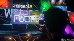 Seorang pengunjung merekam instalasi “Jakarta Water Fountain 2025”, sebuah event tahunan yang menampilkan inovasi tata cahaya dan air di ruang publik. Acara ini mendukung misi Jakpro dan Pemprov DKI dalam memperluas akses hiburan gratis untuk warga.