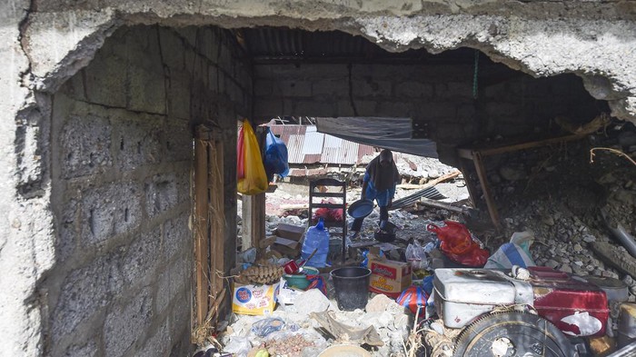 Warga melewati jalan yang terendam banjir di Muaro Ambius, Nagari Guguak Malalo, Tanah Datar, Sumatera Barat, Sabtu (13/12/2025). Hingga hari ke-17 pascabencana, sejumlah warga mulai beraktivitas di luar rumah untuk mengumpulkan barang-barang berharga miliknya yang rusak dan sempat hilang saat banjir bandang. ANTARA FOTO/Wahdi Septiawan/tom.